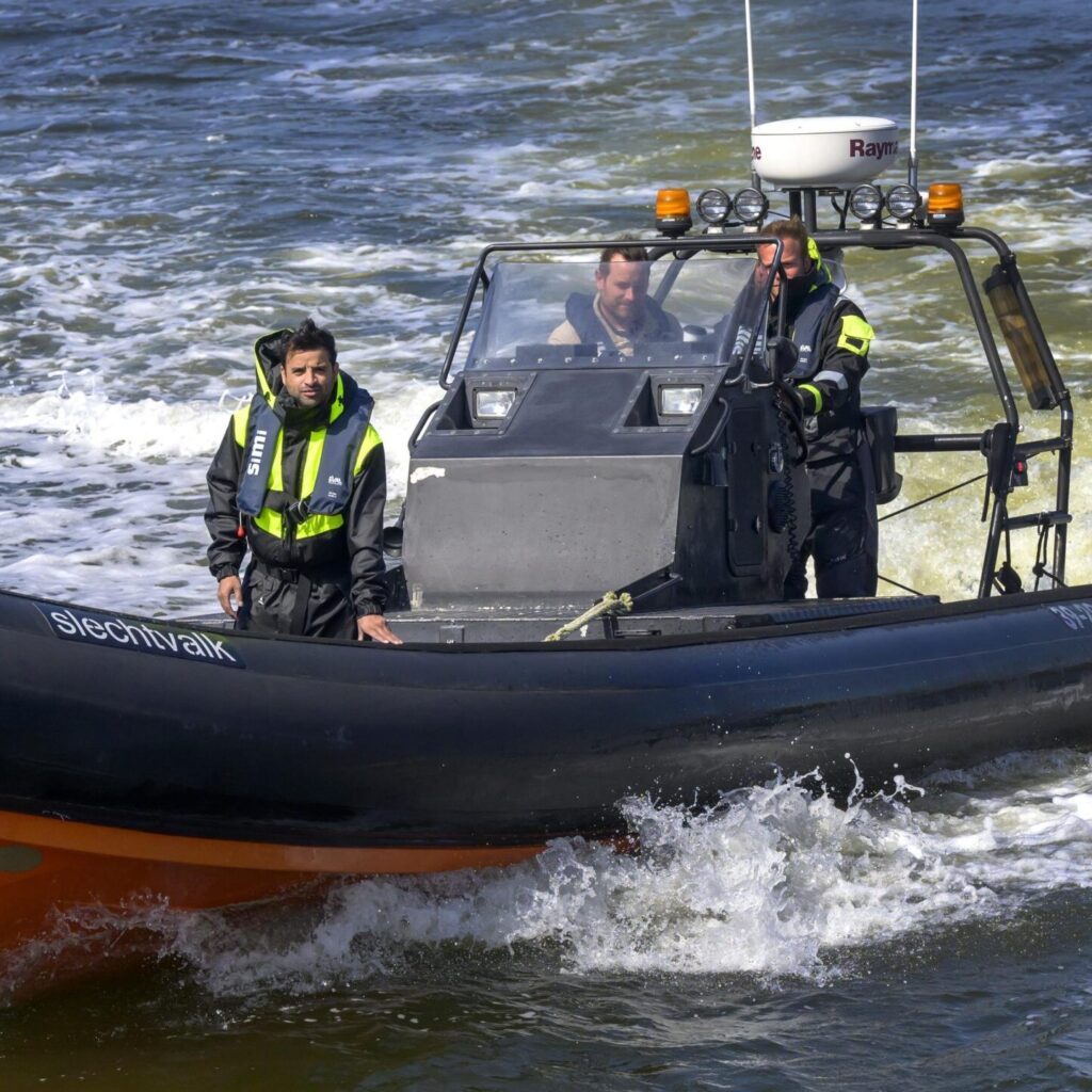 Drie mannen op een boot die komen aanvaren - vooraangezicht